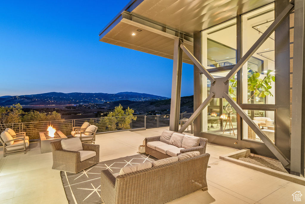 View of patio with a mountain view and an outdoor living space with a fire pit