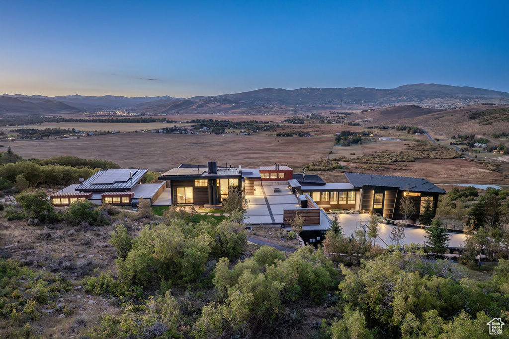 Rear view of property with a mountain view and roof mounted solar panels