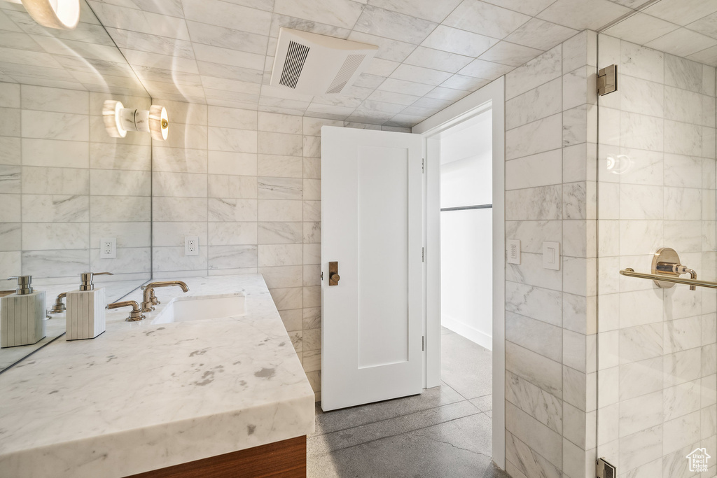 Bathroom featuring vanity and tile walls
