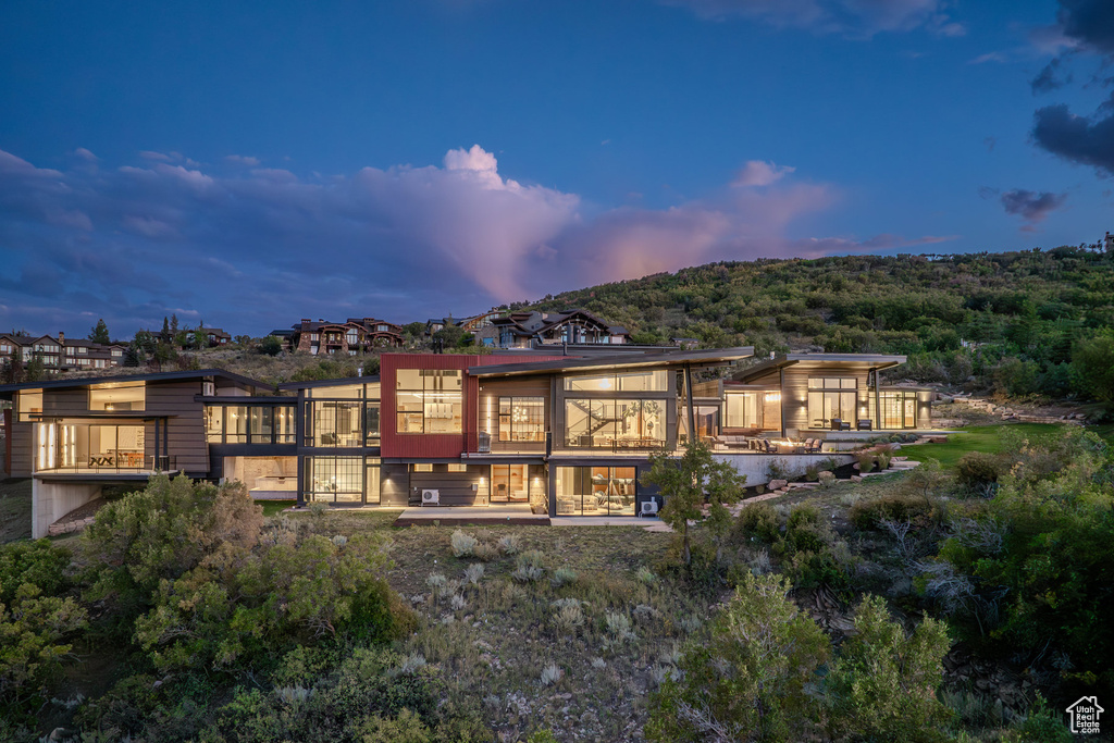Back of house at dusk featuring a balcony
