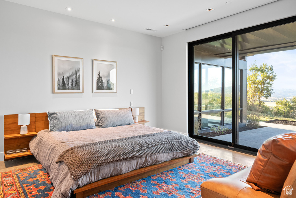 Bedroom with access to outside, multiple windows, and recessed lighting