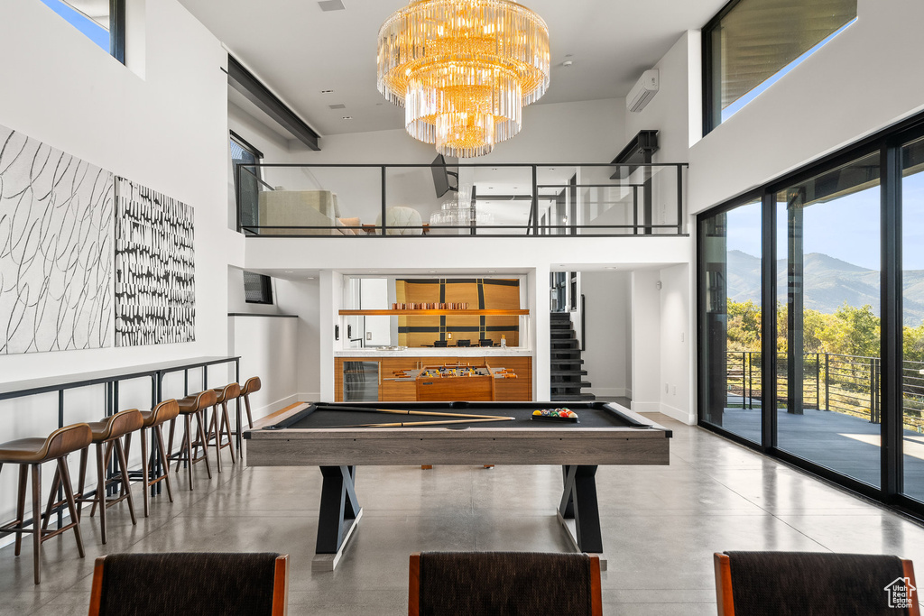 Game room with a high ceiling, a community bar, a mountain view, billiards table, and a chandelier