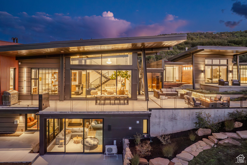 Back of property at dusk featuring an outdoor hangout area and a patio