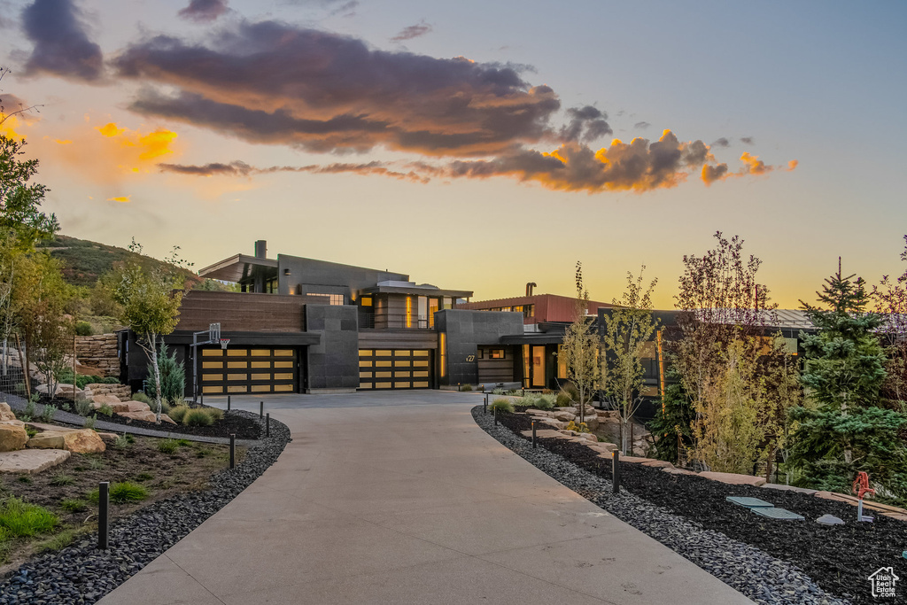 Modern home with driveway, a gate, and an attached garage
