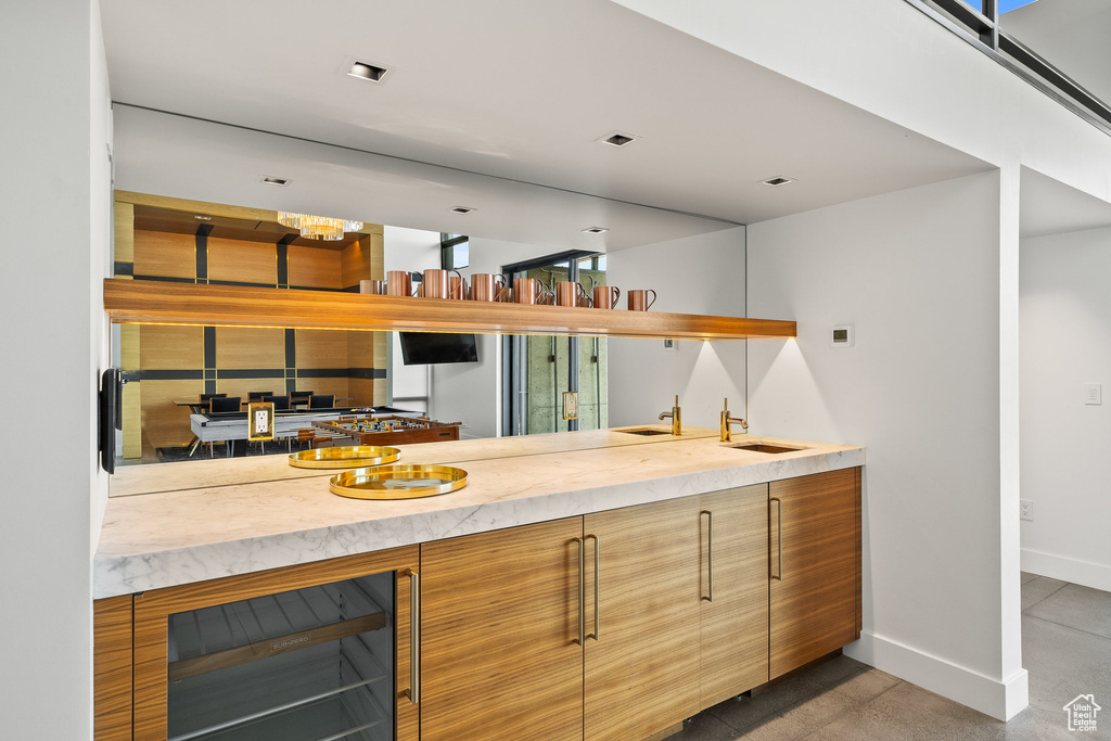 Kitchen with beverage cooler, modern cabinets, and light countertops
