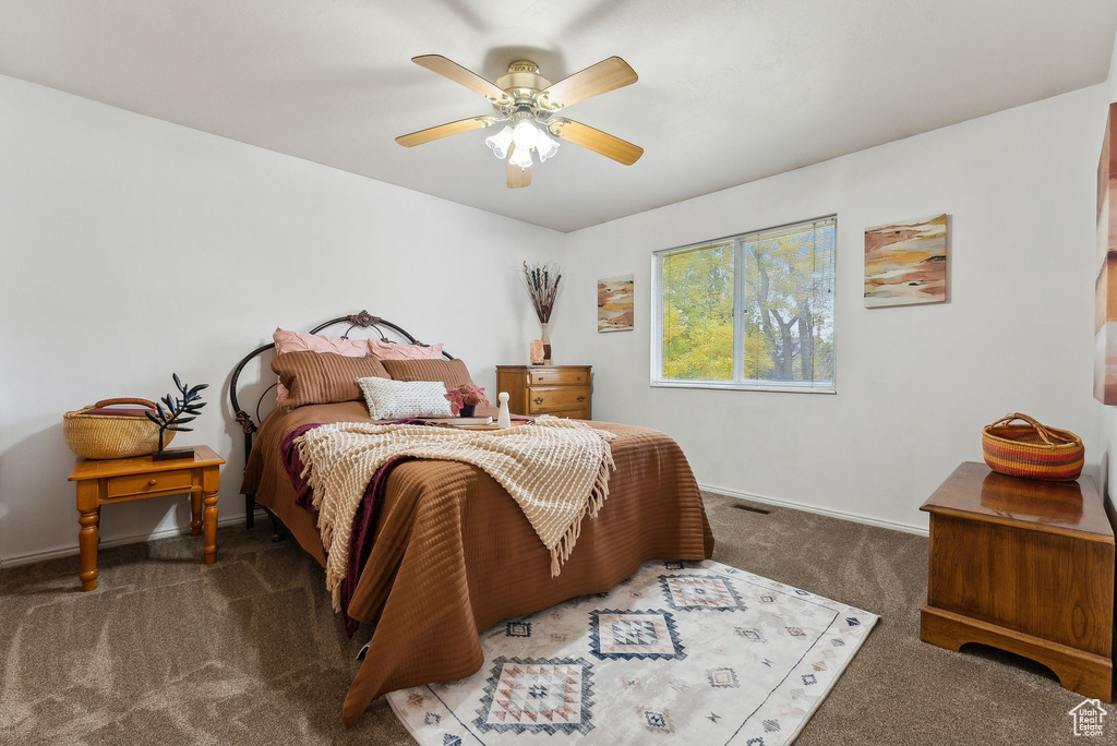 Bedroom with ceiling fan and dark carpet