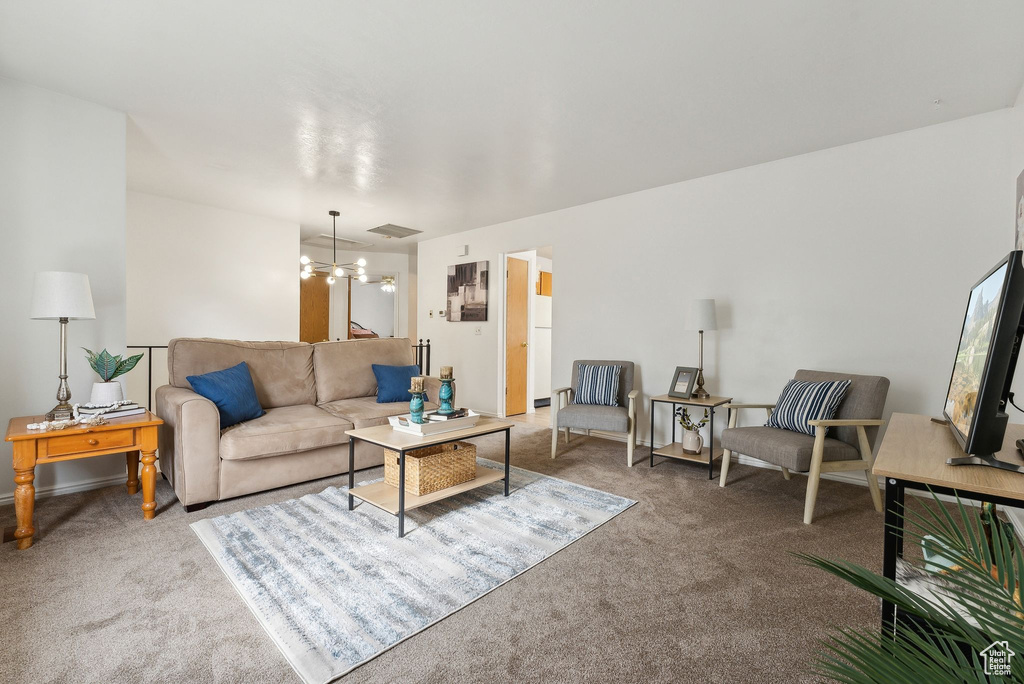 Carpeted living room with a chandelier