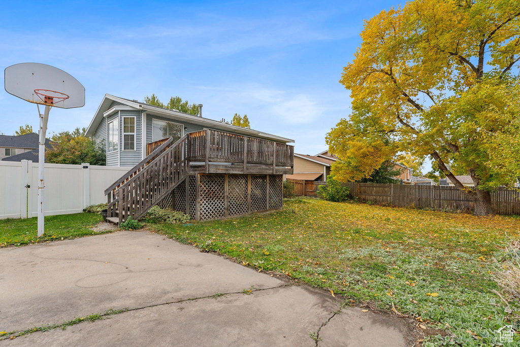 Rear view of house with a deck and a lawn