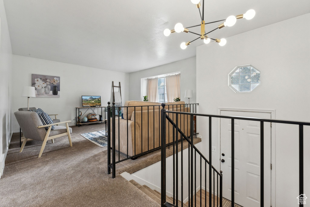 Hallway featuring a chandelier and carpet floors