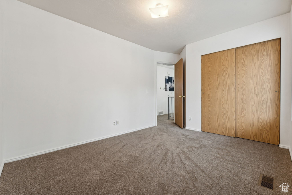 Unfurnished bedroom featuring a closet and carpet