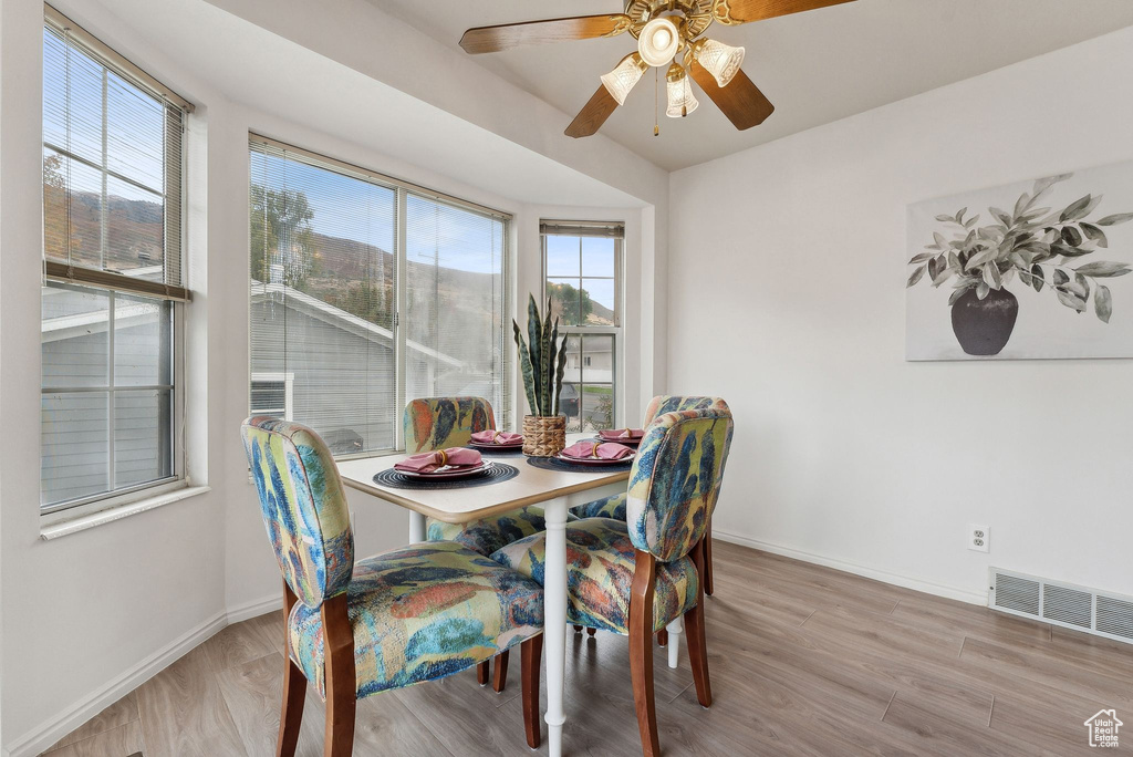 Dining area with light hardwood / wood-style floors and ceiling fan