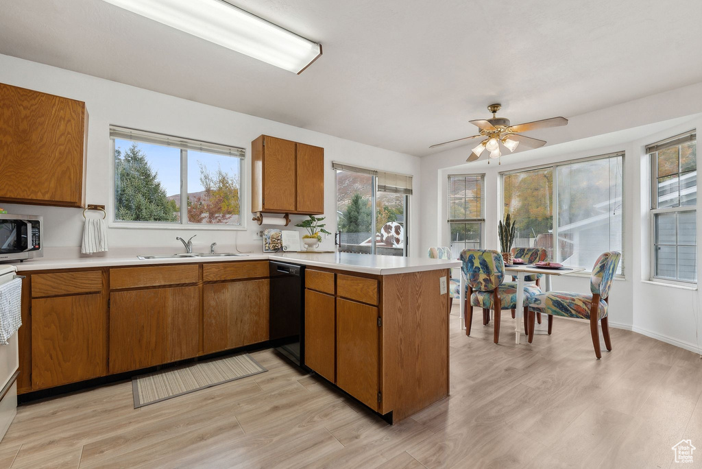 Kitchen featuring kitchen peninsula, ceiling fan, dishwasher, light hardwood / wood-style floors, and sink