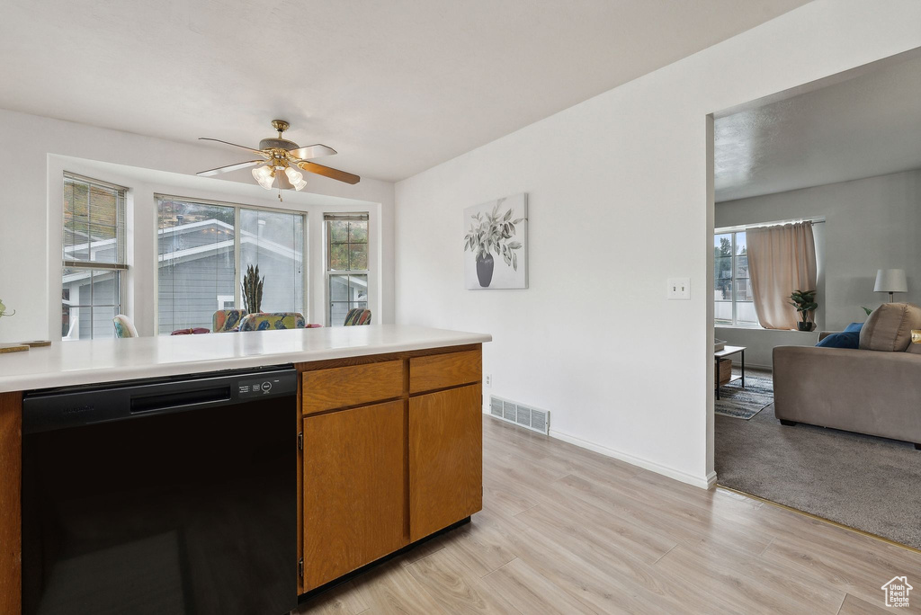 Kitchen featuring ceiling fan, dishwasher, and light wood-type flooring