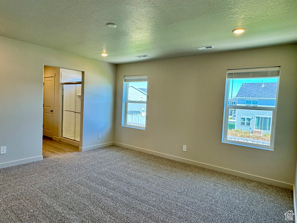 Spare room with a textured ceiling and light carpet