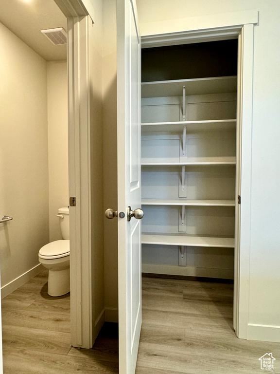 Interior space with wood-type flooring and toilet