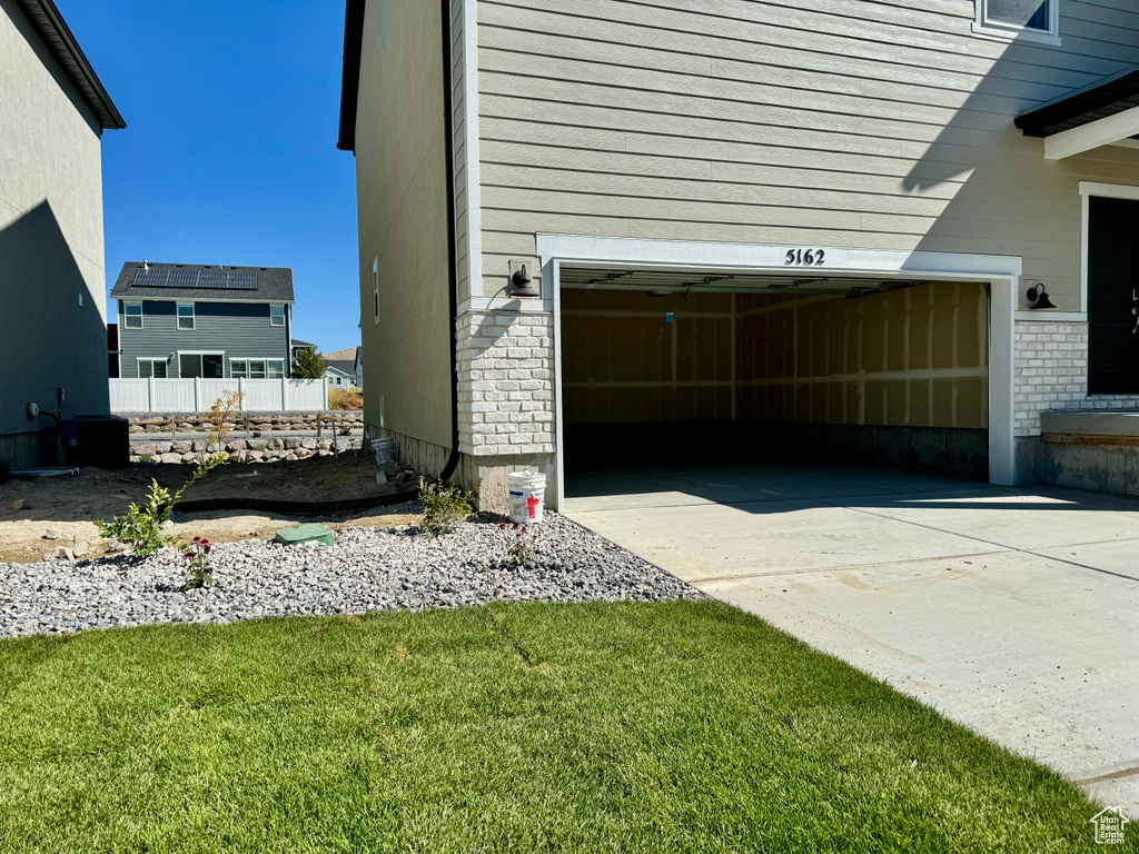 View of side of property featuring a yard and a garage