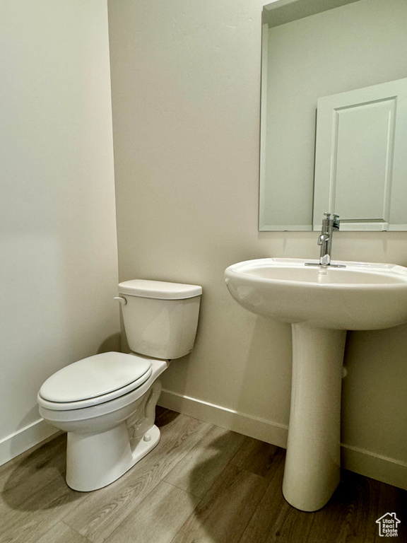 Bathroom featuring sink, hardwood / wood-style floors, and toilet