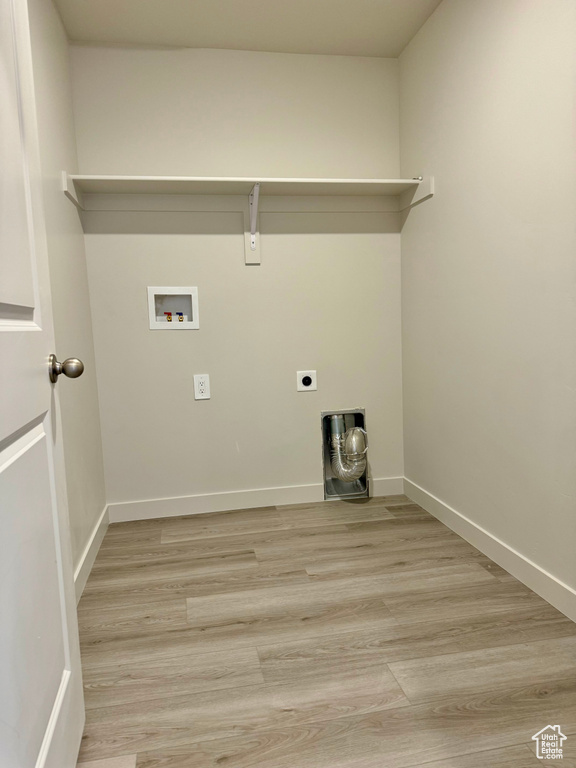 Laundry area featuring light hardwood / wood-style floors, hookup for an electric dryer, and washer hookup