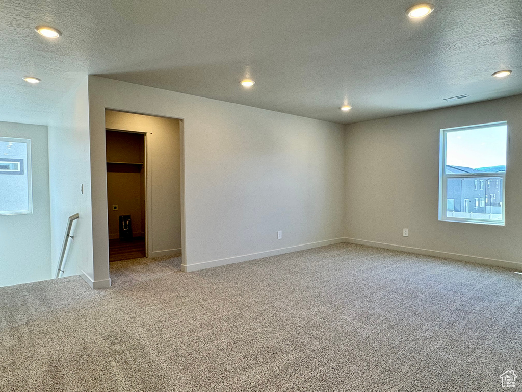 Spare room featuring a textured ceiling and carpet flooring