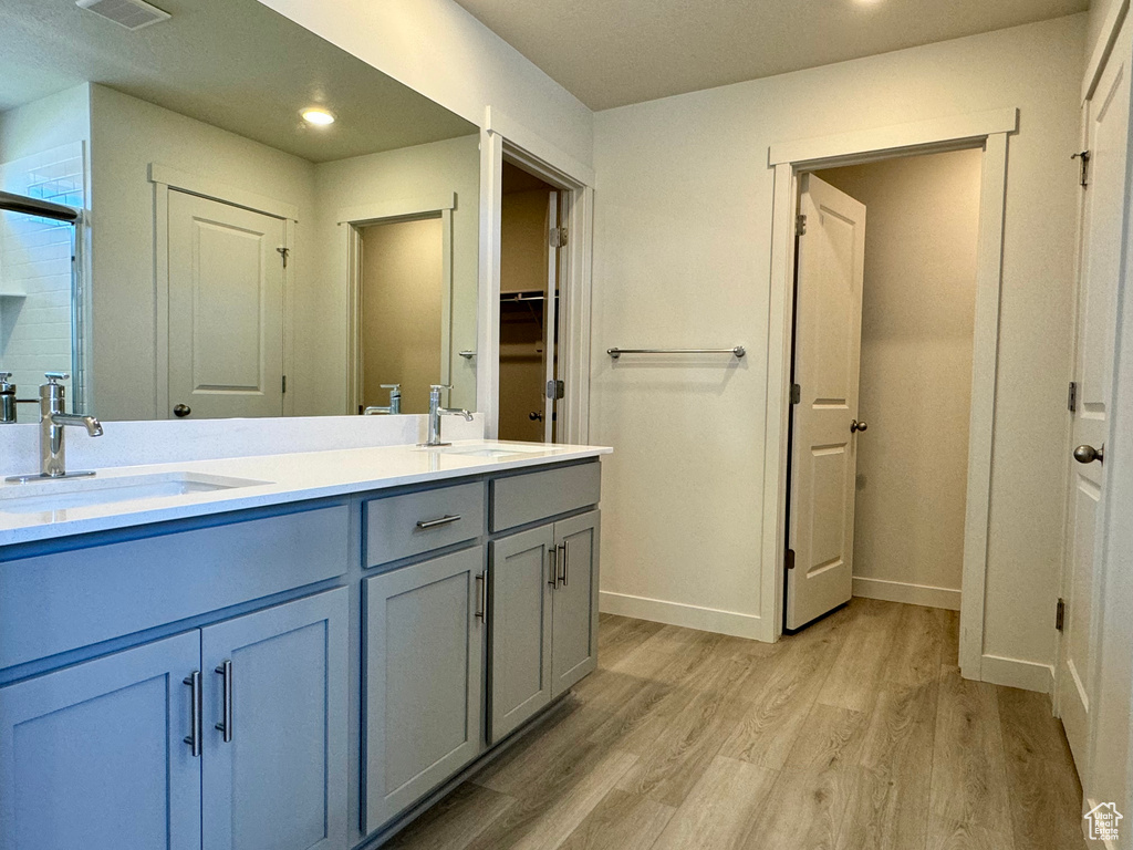 Bathroom featuring walk in shower, vanity, and hardwood / wood-style floors