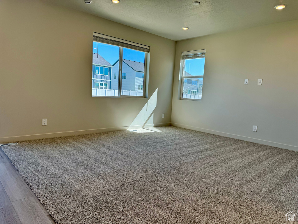 Spare room featuring a healthy amount of sunlight and light hardwood / wood-style flooring