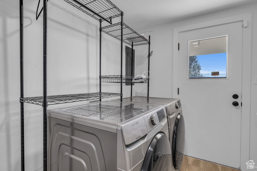 Laundry area with light hardwood / wood-style flooring and washer and dryer