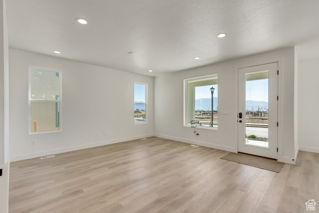 Unfurnished room with light wood-type flooring and a textured ceiling