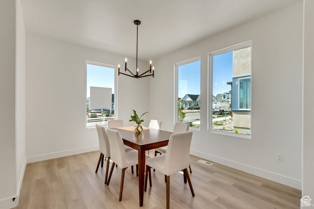 Dining area with an inviting chandelier and light wood-type flooring