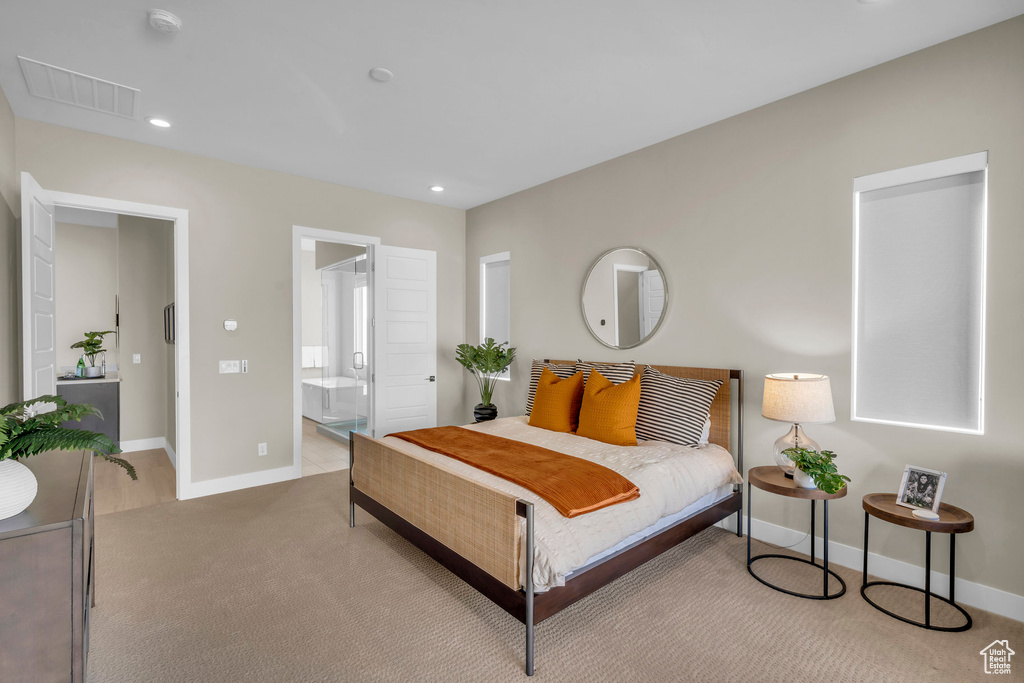 Bedroom featuring light carpet and connected bathroom