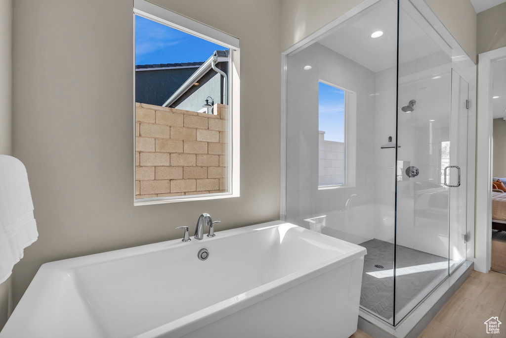 Bathroom featuring independent shower and bath and hardwood / wood-style floors