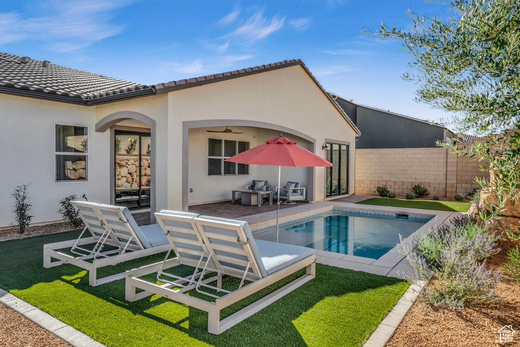 View of swimming pool with a yard and a patio