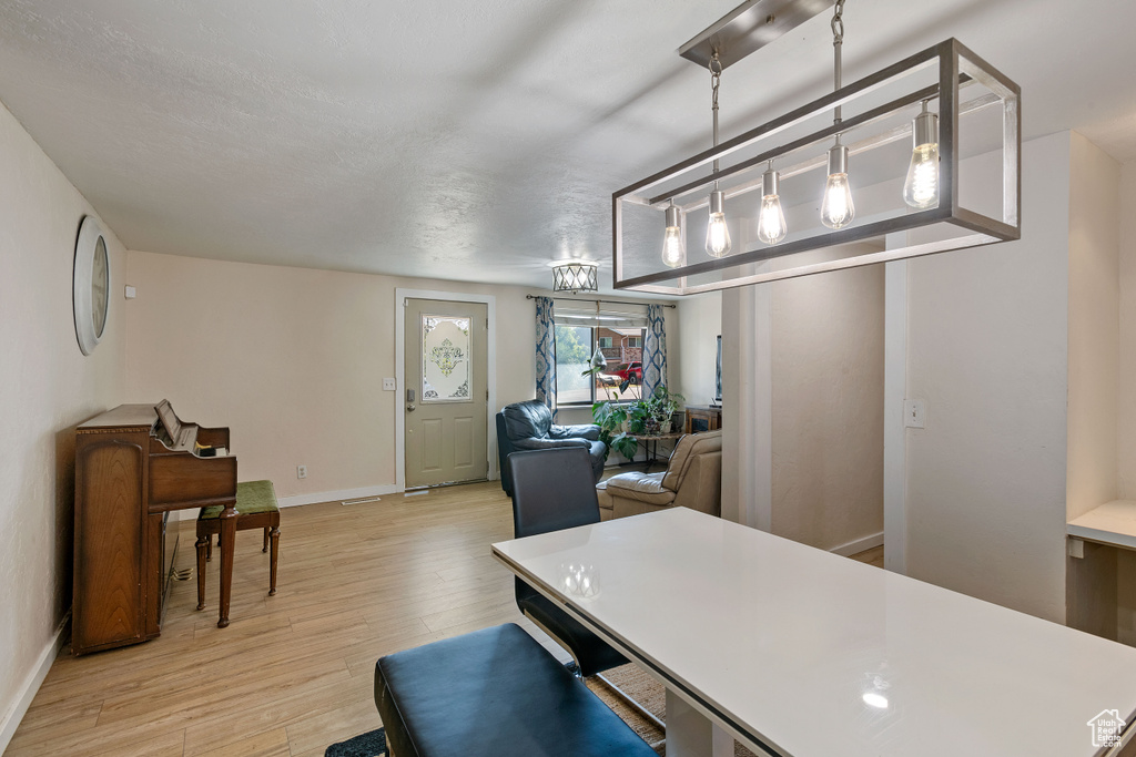 Kitchen with pendant lighting, a textured ceiling, and light hardwood / wood-style flooring