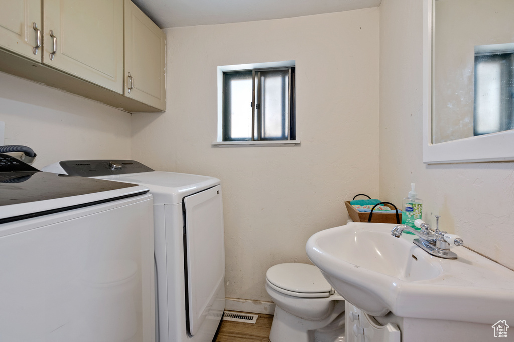 Laundry room with wood-type flooring and washer and dryer