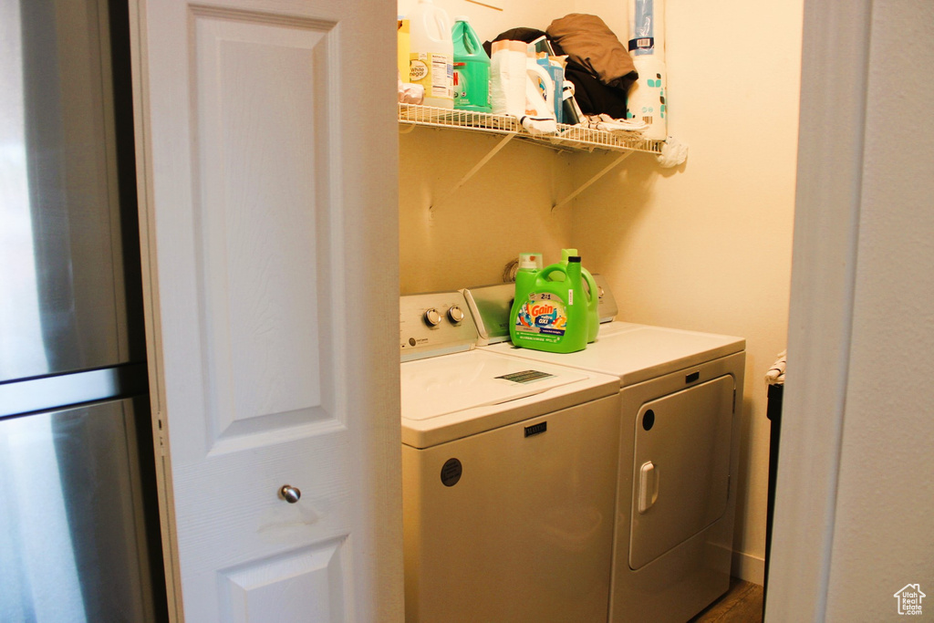 Washroom with hardwood / wood-style floors and separate washer and dryer