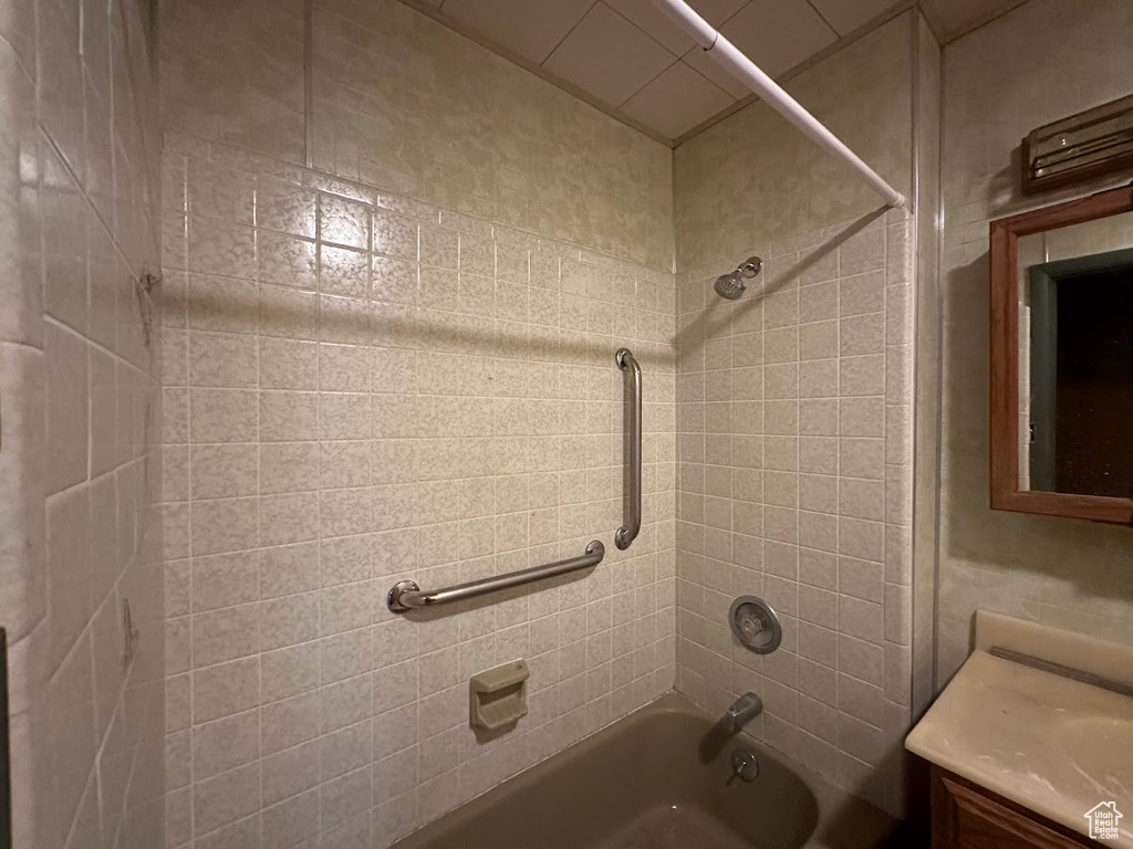 Bathroom with tiled shower / bath and vanity