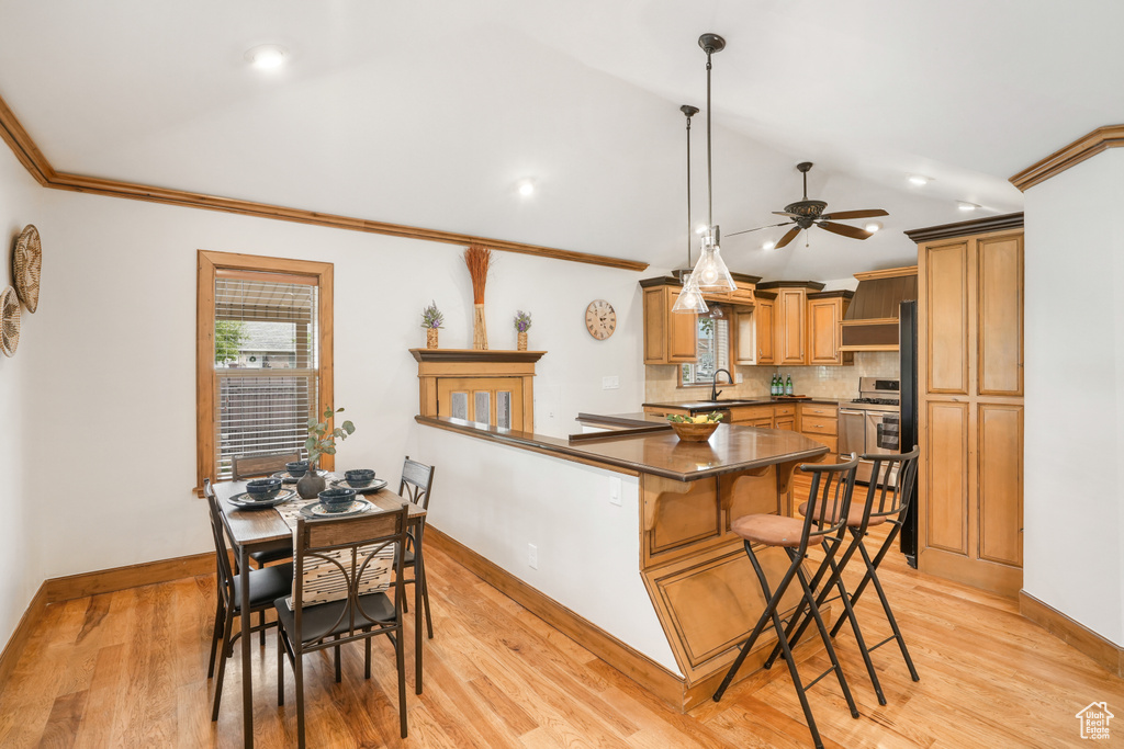 Kitchen with light wood-type flooring, ceiling fan, decorative light fixtures, and sink