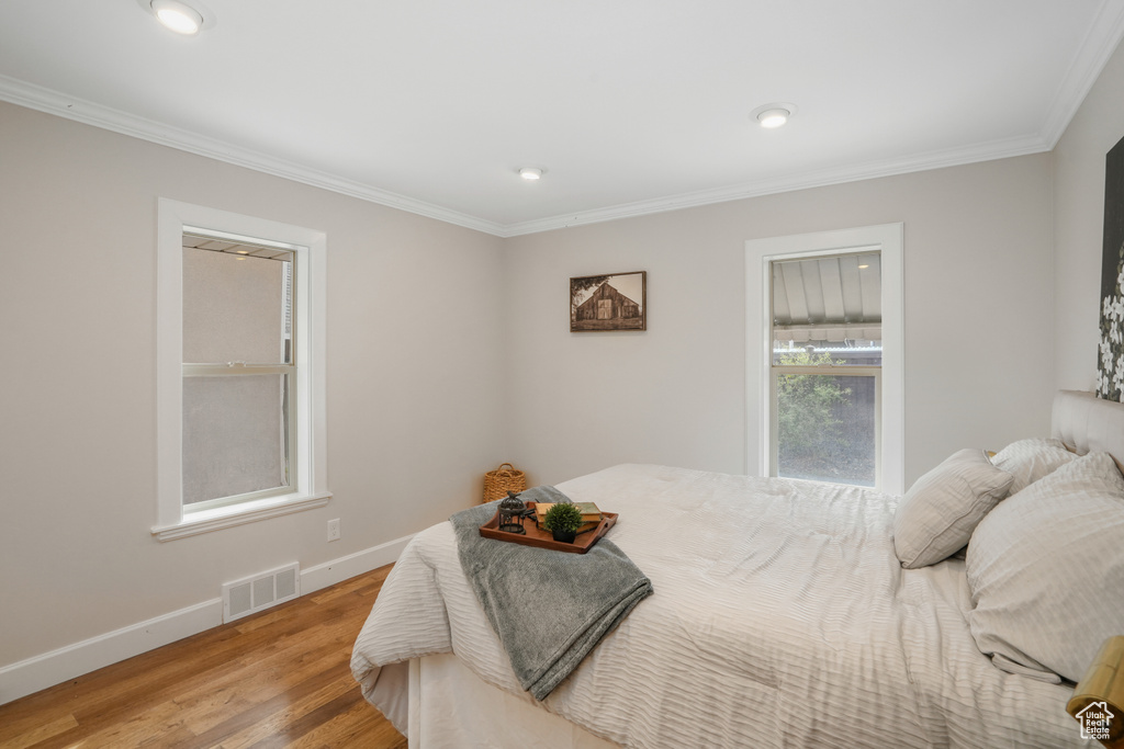 Bedroom featuring ornamental molding and hardwood / wood-style floors