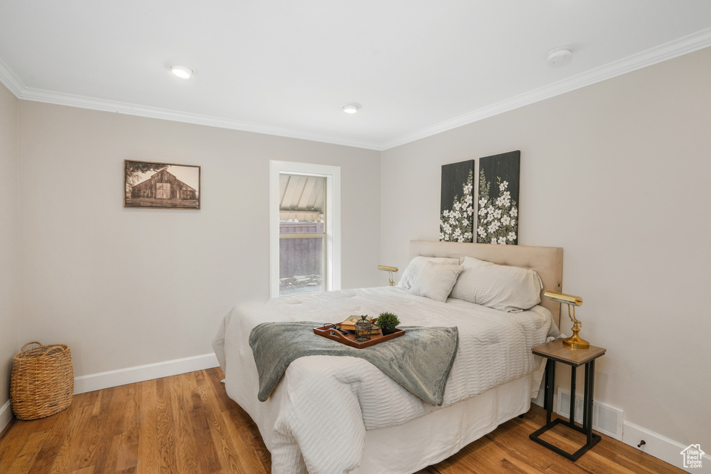 Bedroom featuring hardwood / wood-style flooring and ornamental molding