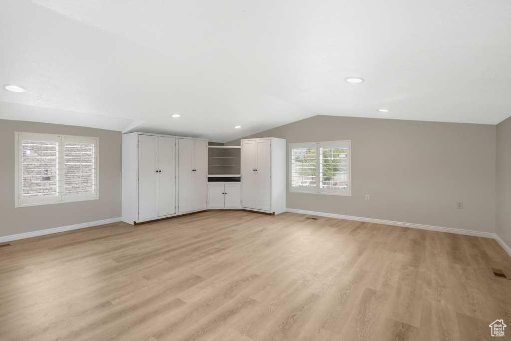 Unfurnished living room with light hardwood / wood-style flooring and lofted ceiling