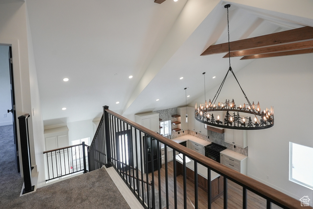 Staircase with lofted ceiling with beams
