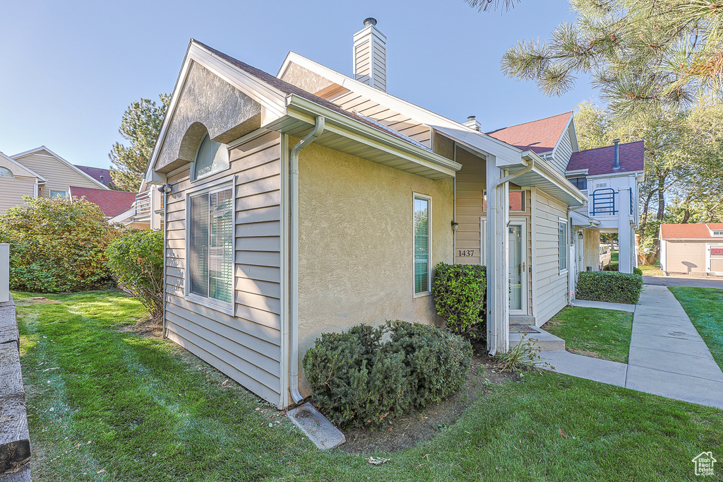 View of property exterior featuring a yard