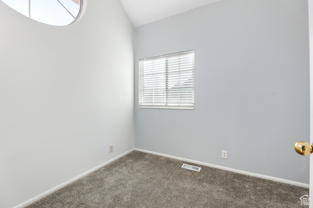 Carpeted empty room with vaulted ceiling