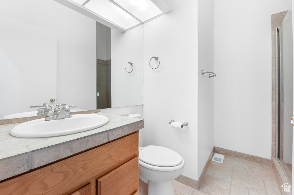 Bathroom featuring vanity, toilet, and an enclosed shower