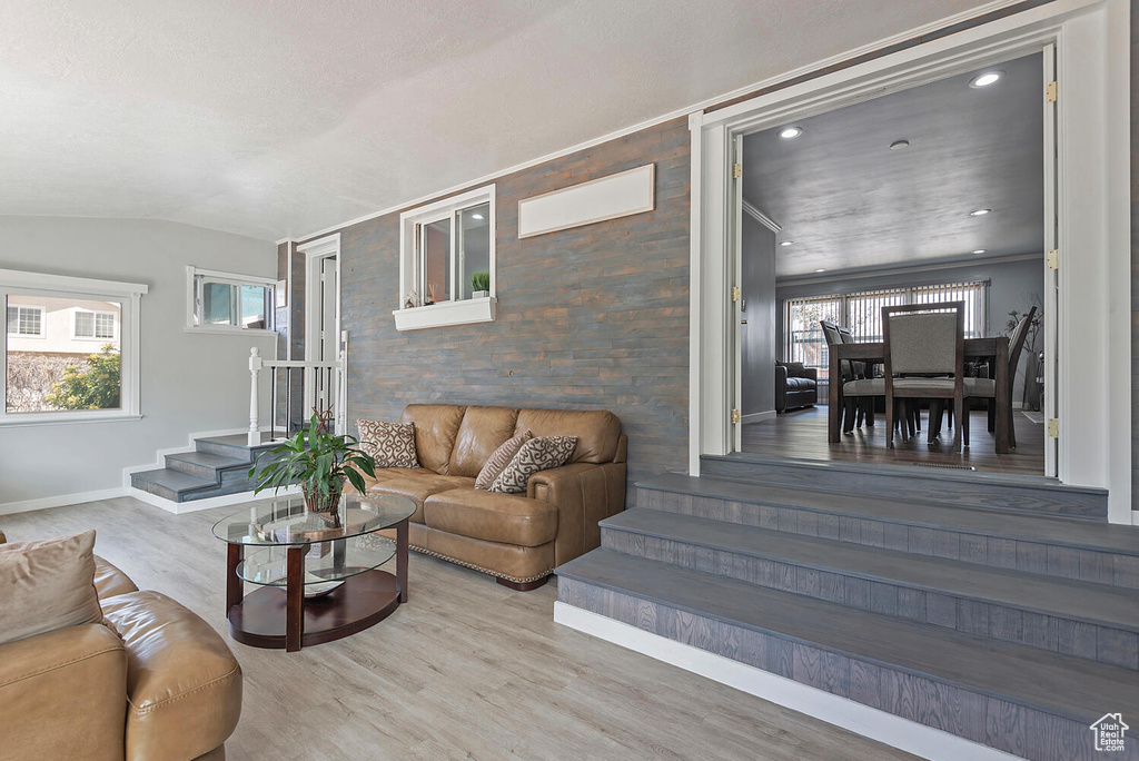 Living room with lofted ceiling, hardwood / wood-style floors, and a healthy amount of sunlight