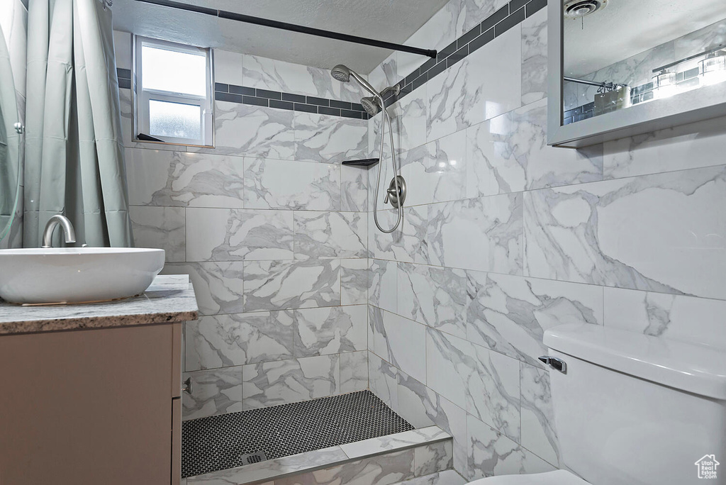 Bathroom featuring vanity, toilet, and a shower with curtain