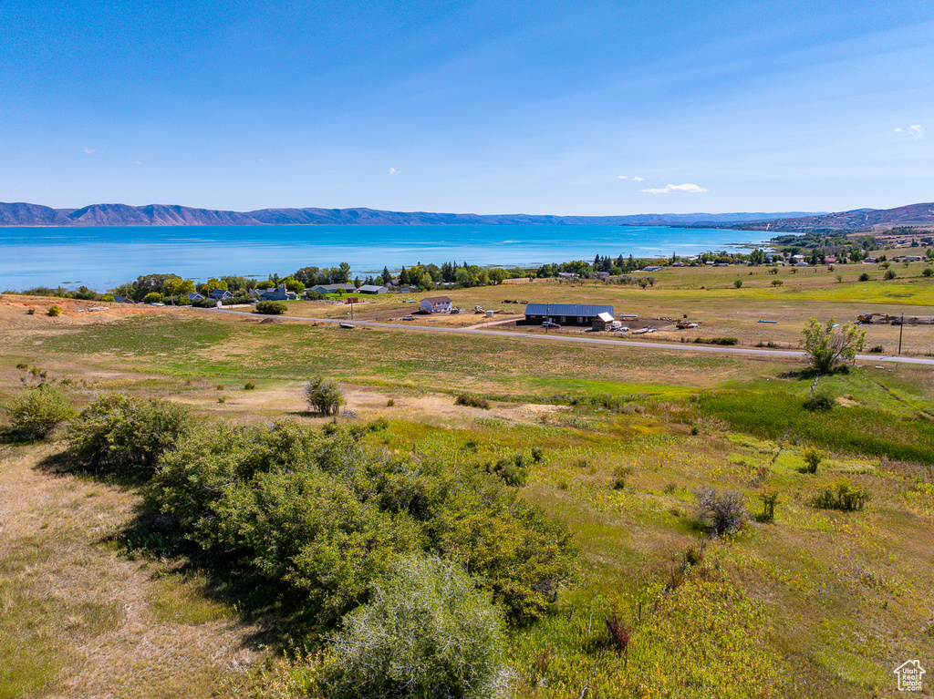 Drone / aerial view with a water and mountain view and a rural view