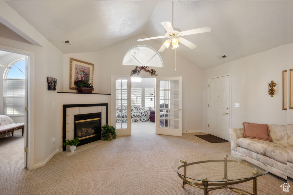 Living room featuring carpet, lofted ceiling, ceiling fan, and a fireplace