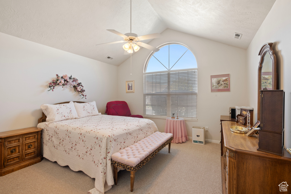 Bedroom featuring lofted ceiling, ceiling fan, light colored carpet, and a textured ceiling