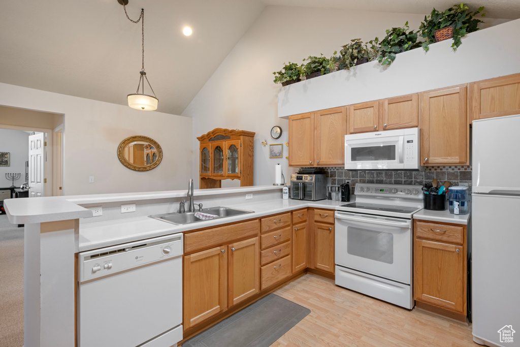 Kitchen featuring sink, kitchen peninsula, decorative backsplash, high vaulted ceiling, and white appliances