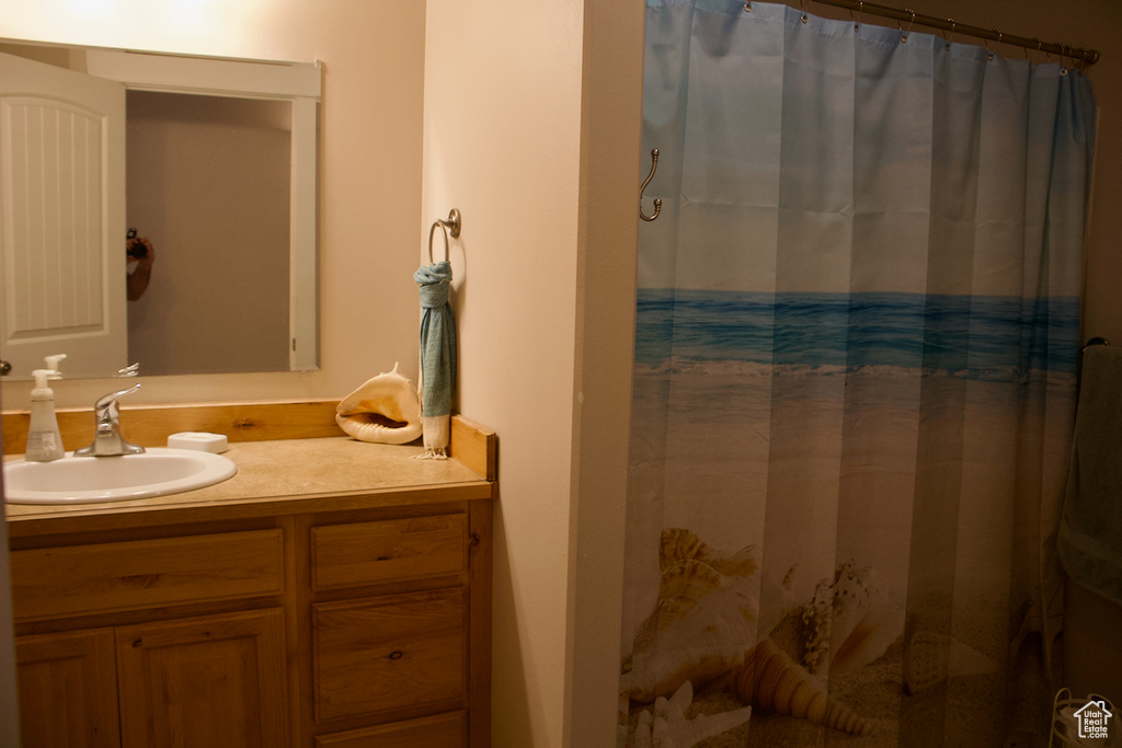 Bathroom with a shower with curtain and vanity